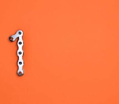 Metal chain forming the number one on an orange background, ideal for design concepts.